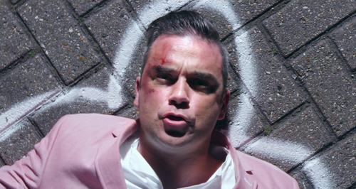 Robbie Williams wearing pink suit in Candy video